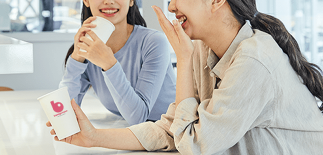 바나프레소 음료를 들고 웃는 사람들